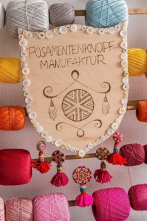 Posamentenknopf wooden crest with button border and hanging tassels at Posamenten manufacturer