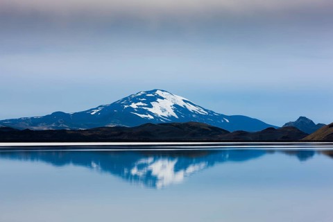 Reflection of the snow-covered volcanic cone Hekla in Hrauneyjalon