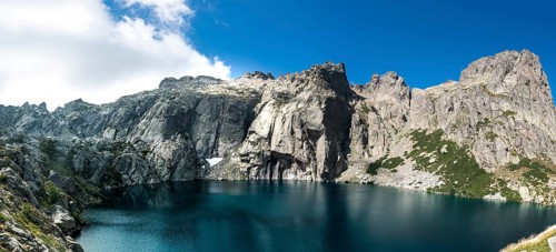 Mountain lake Lac de Capitello surrounded by steep faces