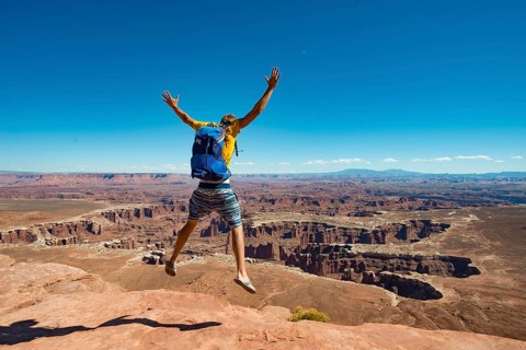 Young man jumping with outstretched arms