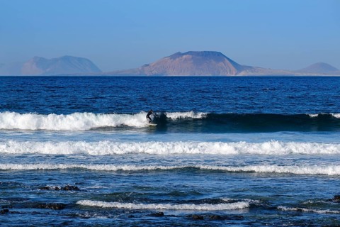 Wave surfers on waves at Caleta de Famara