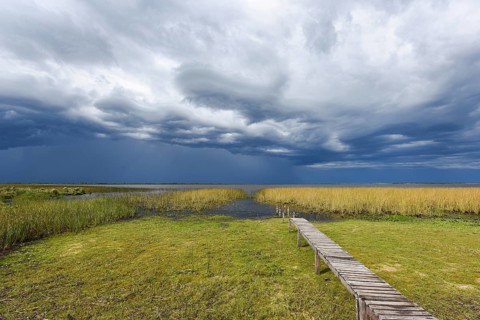 Footbridge at the lakeside with dramatic sky