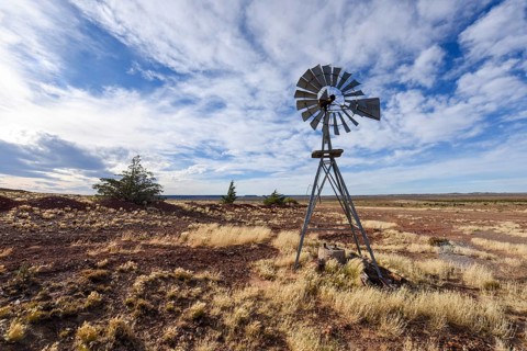 Pampa with old windmill on a farm in Bosques Petrificados de Jaramillo National Park