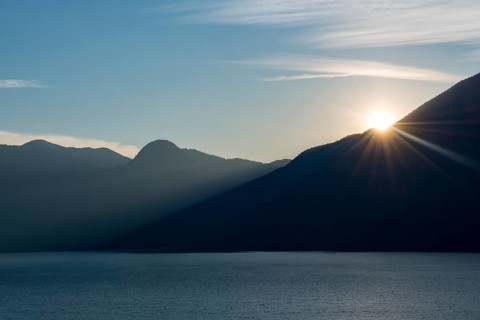 Evening sun shines over mountain silhouette