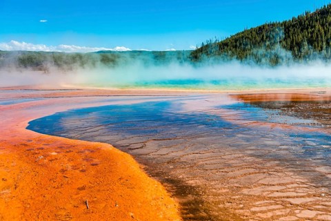 Colored mineral deposits at the edge of the steaming hot spring