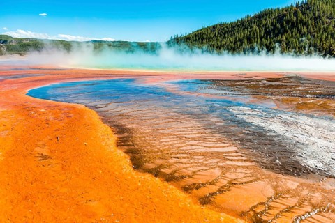 Colored mineral deposits at the edge of the steaming hot spring
