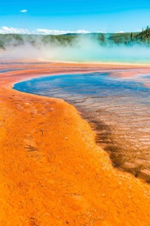 Colored mineral deposits at the edge of the steaming hot spring