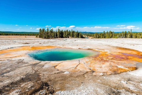 Steaming hot spring with colored mineral deposits