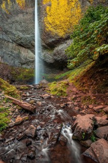 Man at waterfall in front of basalt rock