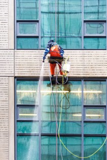 Window cleaner ropes down a high-rise building