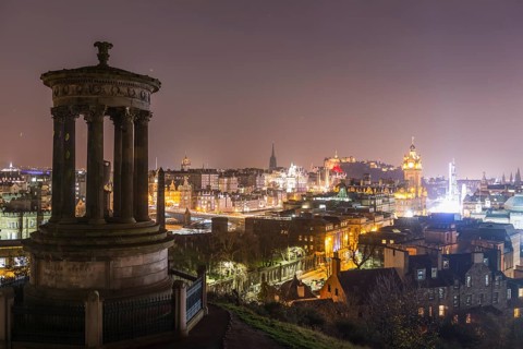 View from Calton Hill with the Dugald Stewart Monument over the historic Old Town with Edinburgh Castle at night