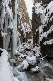 Wild river Partnach in the Partnachklamm with long icicles and snow in winter