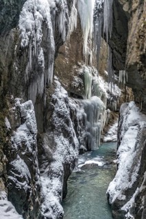 Wild river Partnach in the Partnachklamm with long icicles and snow in winter