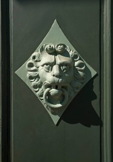 Lion head as a door knocker on a door