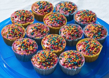 Cupcakes with colorful sugar pearls on blue plate
