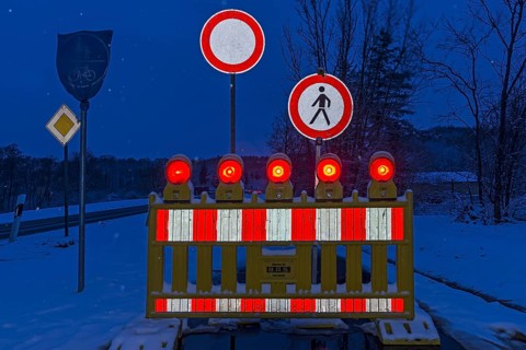 Illuminated snow barrier in winter at dusk