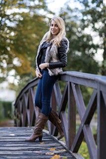 Young blonde woman poses on wooden bridge
