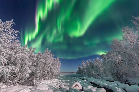 Northern Lights (Aurora Borealis) over snowy river landscape