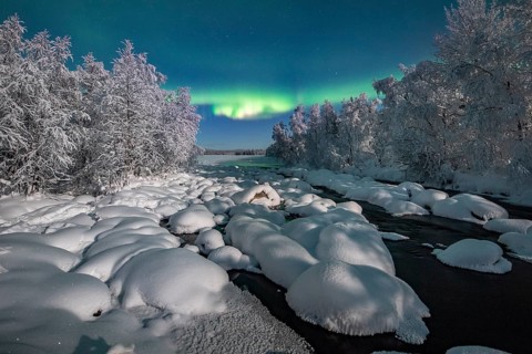 Northern Lights (Aurora Borealis) over snowy river landscape