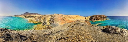 Rocky coastline and sandy beach with turquoise waters of Playa del Papagayo