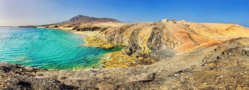 Rocky coast and sand beach with turquoise waters of Playa del Papagayo