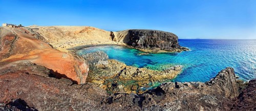Sandy beach and rocky coastline with turquoise waters of Playa del Papagayo