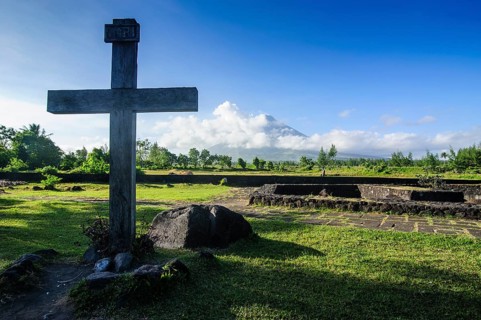Christian cross before volcano Mayon