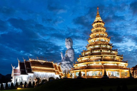 Nine-storey Chinese pagoda and chapel with huge Guan Yin statue at dusk