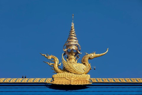 Golden decorated mythical phoenix figure on the roof of Wat Rong Seur Ten