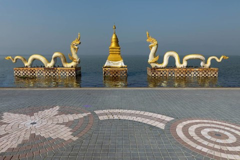 White Naga statues with golden Chedi on the shore of Lake Kwan Phayao