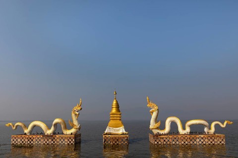 White Naga statues with golden Chedi on the shore of Lake Kwan Phayao