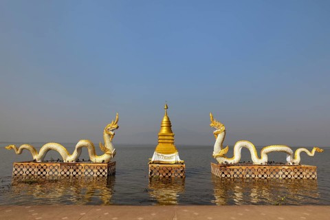 White Naga statues with golden Chedi on the shore of Lake Kwan Phayao
