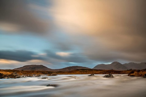 River Ba with mountain peaks in the background and dramatic clouds