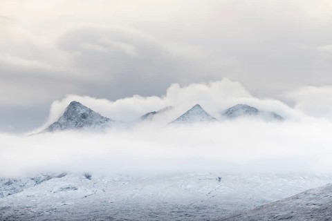 Snow-covered mountain peaks of the Cullins Group with clouds in snow-covered landscape