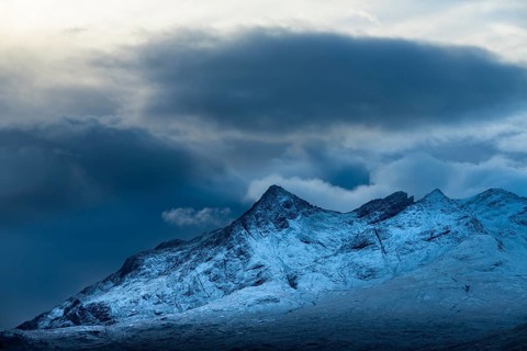 Snow-covered mountain peaks of the Cullins Group with clouds in snow-covered landscape
