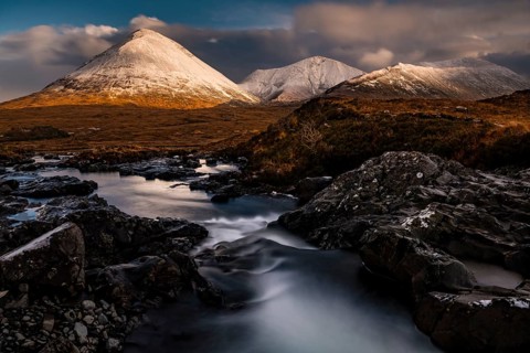 AltDearg Mor with snow-covered peaks of the Cullins Mountains in Highland landscape