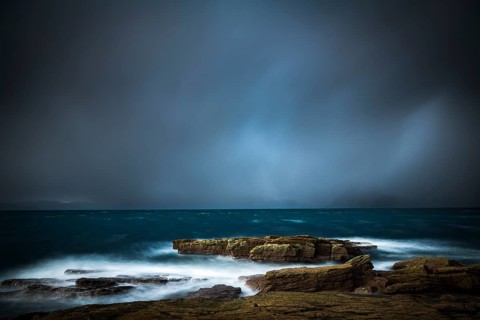 Large rocks in the waters of the North Sea with thunderclouds