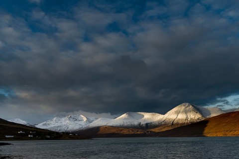 Snow-covered Cullins mountain range with Loch Ainort in dramatic light