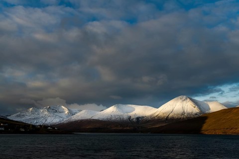 Snow-covered Cullins mountain range with Loch Ainort in dramatic light