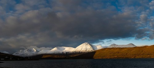 Snow-covered Cullins mountain range with Loch Ainort in dramatic light