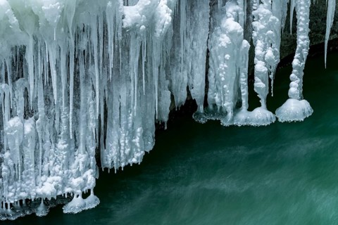Icicles over running water