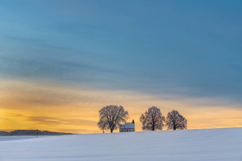 Chapel 14 emergency helpers with old trees in snow-covered landscape at sunrise