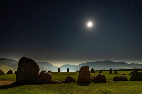 Stone circle at full moon with starry sky