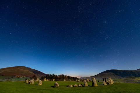 Stone circle at full moon with starry sky