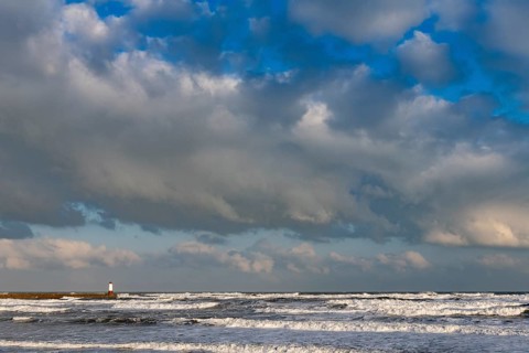 Berwick Lighthouse in strong surf and cloudy sky