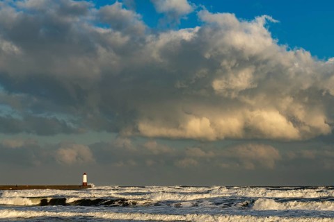 Berwick Lighthouse in strong surf and cloudy sky