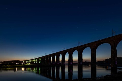 Illuminated railway bridge at night