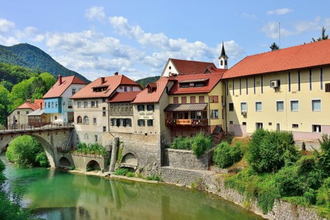 City view Skofja Loka with buildings from the 14th century and the Capuchin bridge over the river Sora