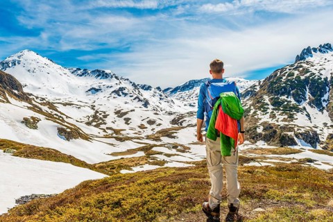 Young man hiker looks into the distance