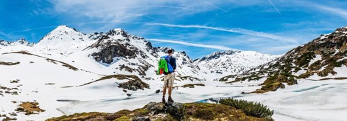 Hiker stands in front of mountain landscape
